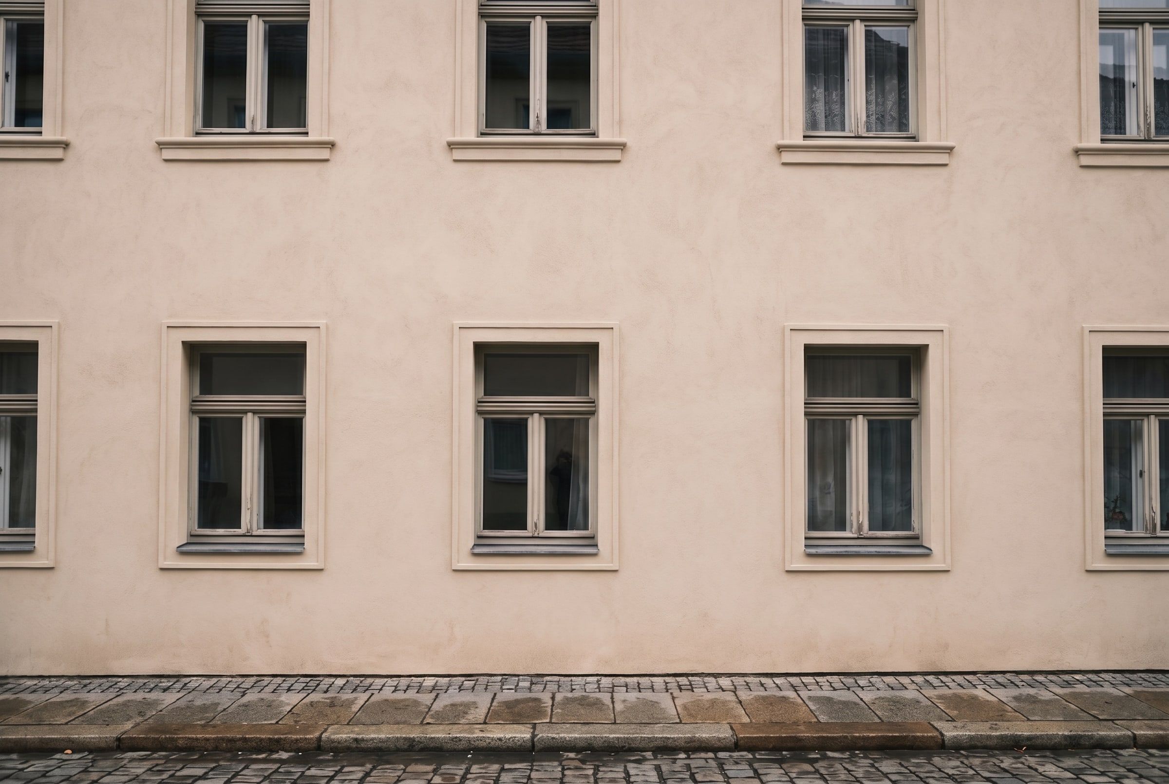 Dieselbe Fassade neu verputzt und gestrichen, mit sauber gezogenen Fensterfaschen